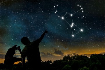 Wall Mural - orion constellation on night sky. astrology concept. silhouettes of adult man and child observing ni
