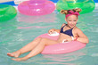 portrait of little girl in tropical style in a swimming pool