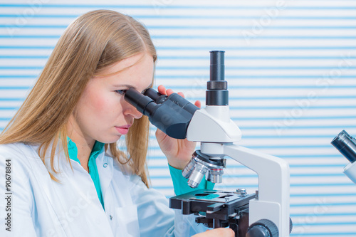 Fotografía Female scientist looking through a microscope in laboratory