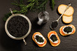 Black caviar served on crackers with vodka and additives