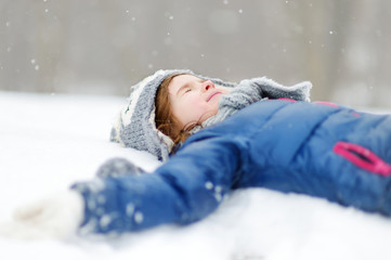 Funny little girl having fun in winter park