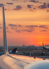 Canvas Print - Sunset at the airport with airplanes ready to take off