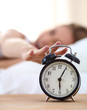 © lenets_tan - Young sleeping woman and alarm clock in bedroom at home