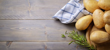 Potatoes And Rosemary On Wooden Background, Top View, Space For Text.