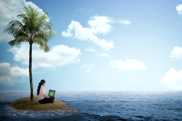 Business woman working with laptop on the small island