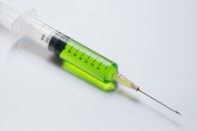 Syringe With Green Liquid On Light Background