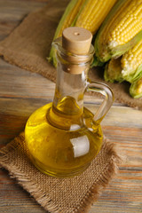 Wall Mural - Bottle of oil with fresh corn on table close up