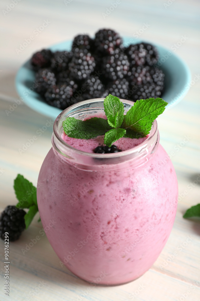 Delicious berry smoothie with blackberries on wooden table close up