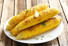 Fresh Tasty Grilled Corn With Butter On Brown Table