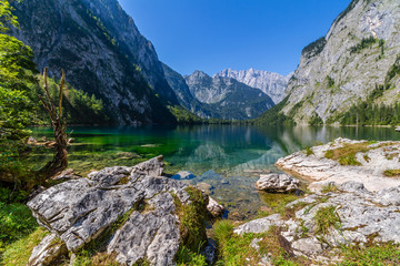 Beautiful landscape of alpine lake with crystal clear green water and mountains in background, Obersee, Germany