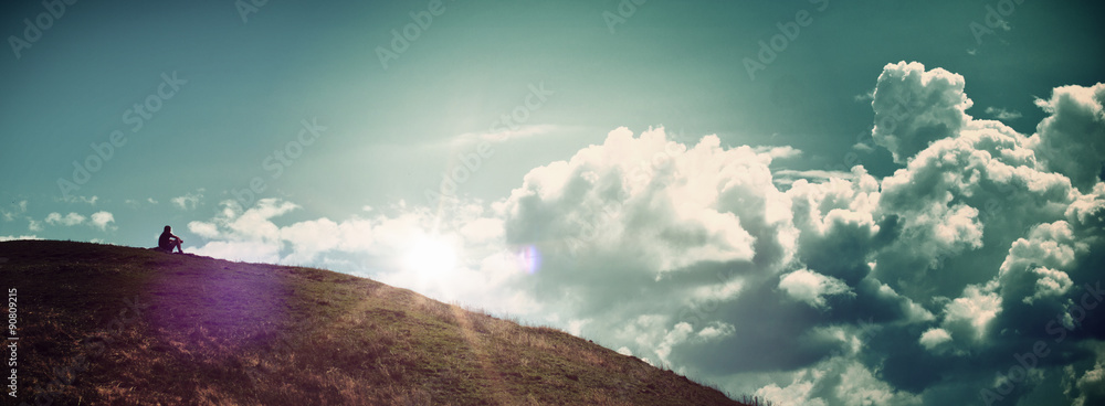 Solitary Person Sitting on Hill Watching Sunrise - obrazy, fototapety, plakaty 