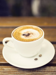 Wall Mural - Cup of cappuccino on a wooden table