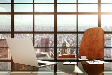 Modern workplace with a laptop and office accessories at sunrise