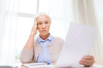 Wall Mural - senior woman with papers and calculator at home