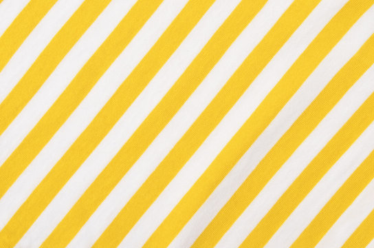 white and yellow striped background. diagonal stripes pattern on fabric.