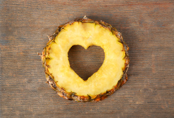 Wall Mural - Pineapple slice with cut in shape of heart on wooden background