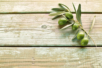 Branch of olive with leaves on wooden background