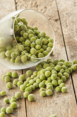 Wall Mural - Frozen peas close up on wooden background