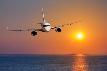 Wall Mural - passenger airplane flying on sunset