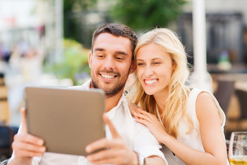 Poster - happy couple with tablet pc at restaurant lounge