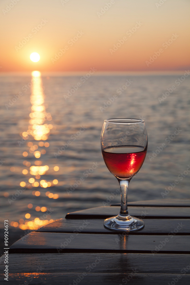 Glas Wein am Meer bei Sonnenuntergang Stock Photo