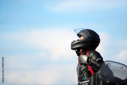 Fototapeta na szkło Motocyklista dziewczyna siedzi na motocyklu w kasku