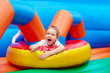 © Olesia Bilkei - happy excited boy having fun on inflatable attraction playground