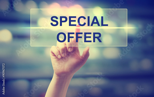 Fotografía Hand pressing a special offer button on blury city lights background