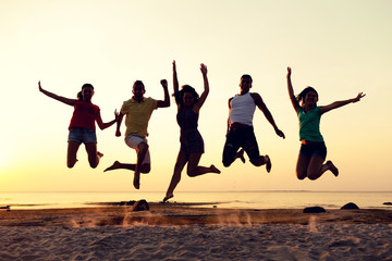 Canvas Print - smiling friends dancing and jumping on beach