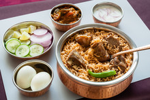 Mutton Biryani With Traditional Sides - Closeup View From The Top Of Delicious Mutton (lamb) Biryani Served In Authentic Copper Utensils With Salad (raita), Gravy And Egg. Natural Light Used.