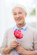 © Syda Productions - happy smiling senior woman with flower at home