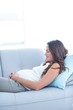 © WavebreakmediaMicro - Smiling pregnant woman relaxing at home