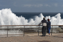 Old People Tourists Observe Waves Crushing On Pier 