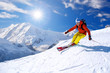 canvas print picture - Skier skiing downhill in high mountains against blue sky