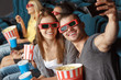 © LENSLOGIC - Two friends making selfie in the cinema