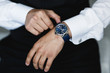 the groom puts on a watch