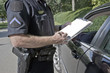 Policeman writing speeding ticket.