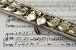 Close up flute on flute sheet music background