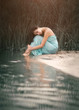 Charming, romantic girl sleeping and dreams near the water
