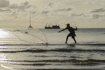 the fisherman he is casting fishing on the seaside