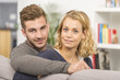 © Atelier 211 - cheerful couple relaxing in sofa at home
