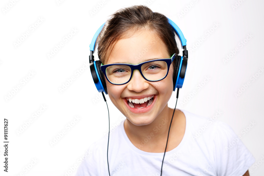 Nastolatka słucha muzyki.
Dziewczynka w słuchawkach na uszach - obrazy, fototapety, plakaty 