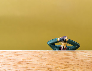 Male Model with Binoculars Spies over a Wooden Wall