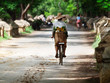 Burmese Woman on a Bicycle: Carrying Bananas in Myanmar