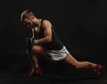 Athletic Bearded Boxer With Gloves On A Dark Background