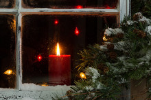 Glowing Christmas Candle In Frosted Home Window