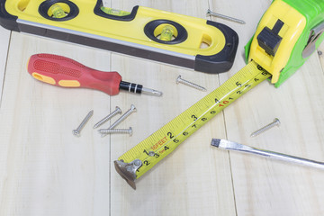 Spirit level , screwdriver , nut , plier on wooden