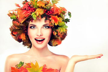 Autumn Beauty - fashion Makeup With Red and yellow autumn Leaves on  girl head . Emotions and surprise on the face of the autumn girl