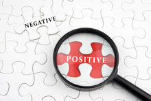 Magnifying Glass On Missing Puzzle With "POSITIVE And NEGATIVE" Word, Antonym Concept, Selective Focus.