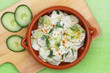 Cucumber salad with sour cream and fresh dill in clay bowl, close up
